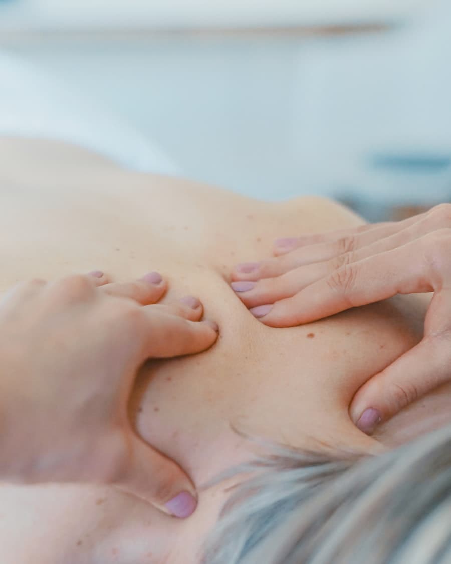 Kinésithérapeute réalisant un massage thérapeutique sur un patient au cabinet